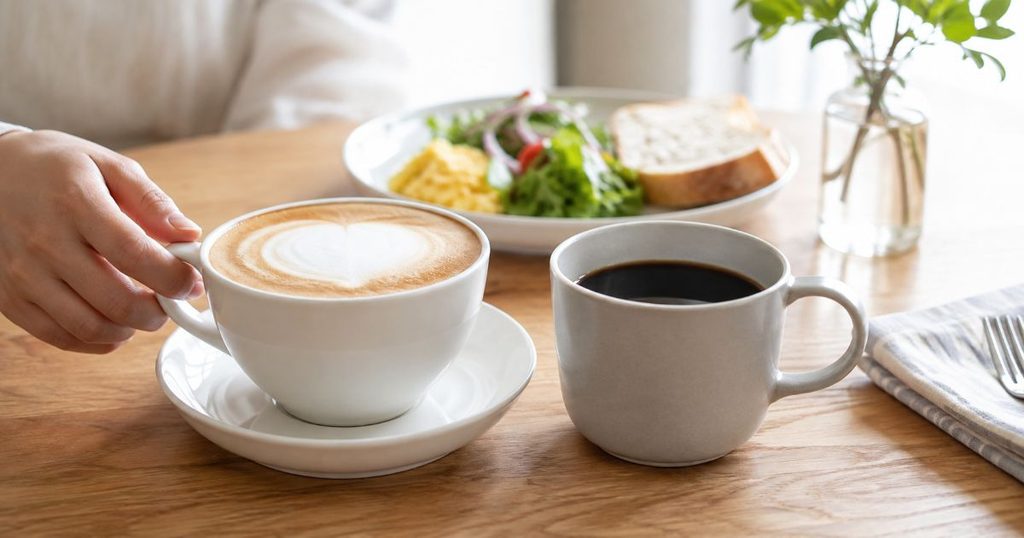 ラテとブラックコーヒーが並ぶ朝食のテーブル