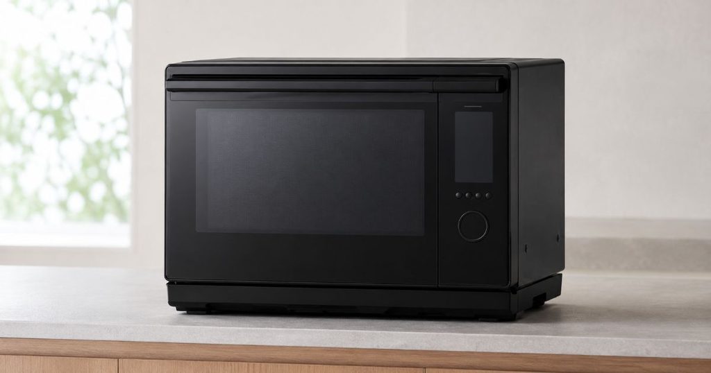 明るいキッチンに置かれた黒いオーブンレンジ