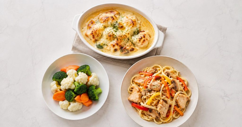 グラタンと温野菜と麺料理を並べた食卓