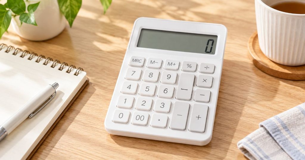 木製テーブルに置かれた白い電卓