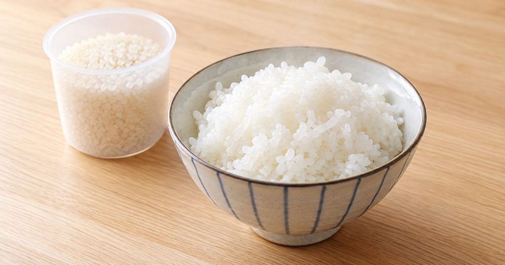 少量の白ごはんと一合用の米計量カップ